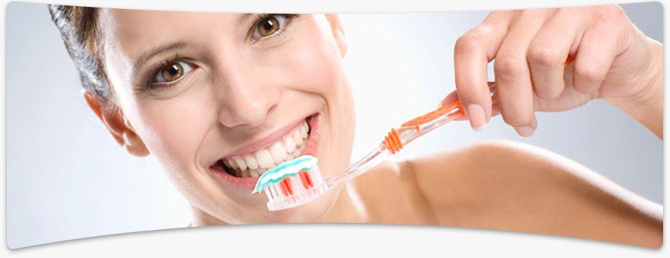Mother and her young daughter brushing their teeth together