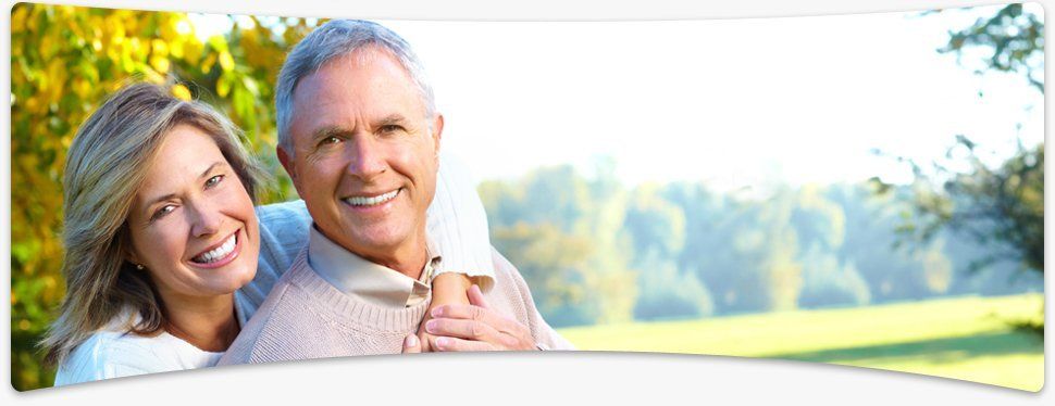 Laughing elderly couple holding hands in their living room