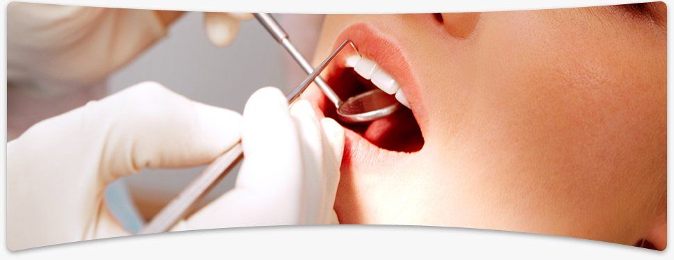 Painful tooth in need of a filling? Call us now on 01905 23808 A dentist and his assistant putting in a filling in an elderly patient