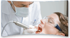 Dentist wearing a mask while  using a drill to add a filling