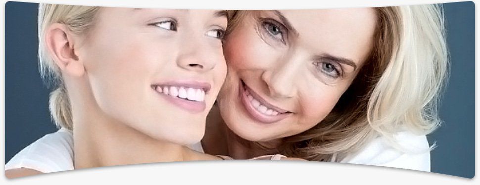 Book your next dental appointment by calling us on 01905 23808 Dental technician in her clinic with her assistant carrying out a dental examination in the background