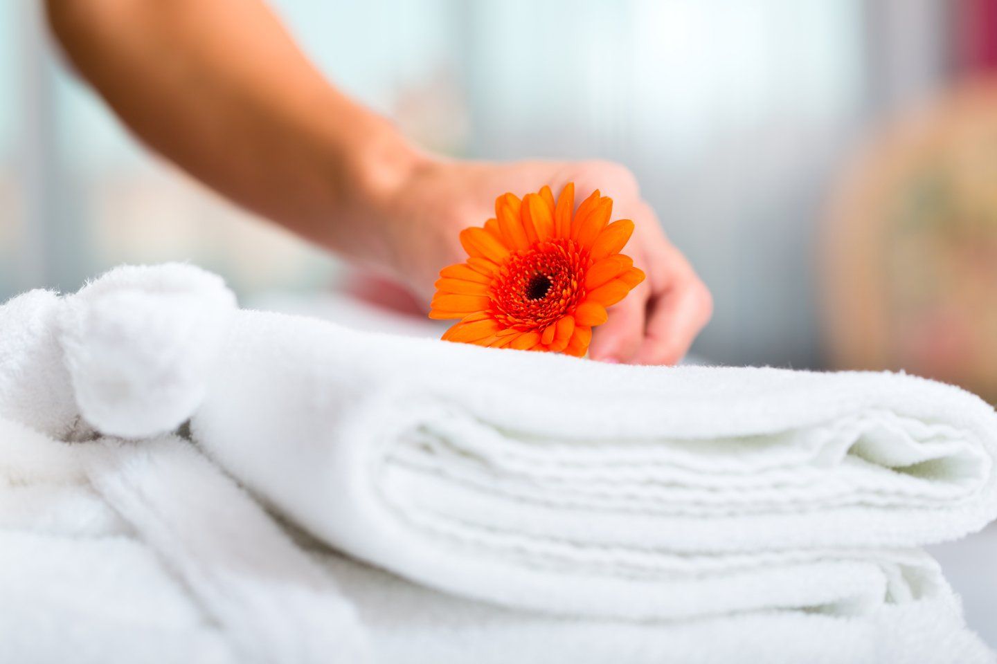 Mano con fiore su biancheria di albergo