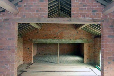 An empty room with brick walls and a wooden floor