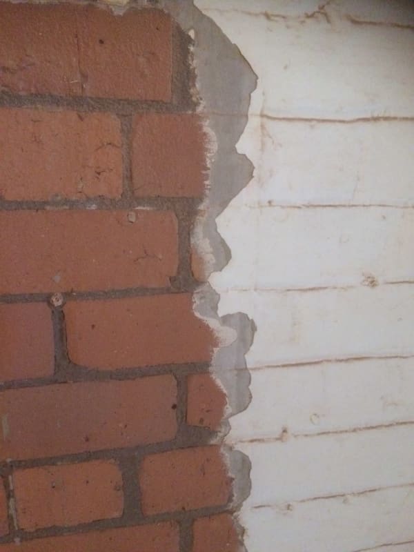 A close up of a brick wall with a hole in it.