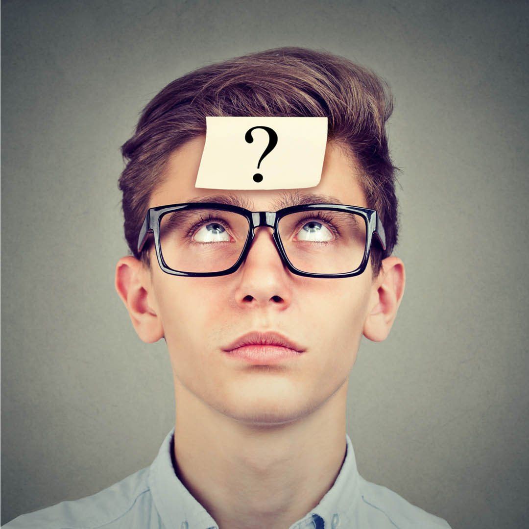 Häufige Fragen (FAQ): Junger Mensch mit Brille hat ein Fragezeichen auf der Stirn