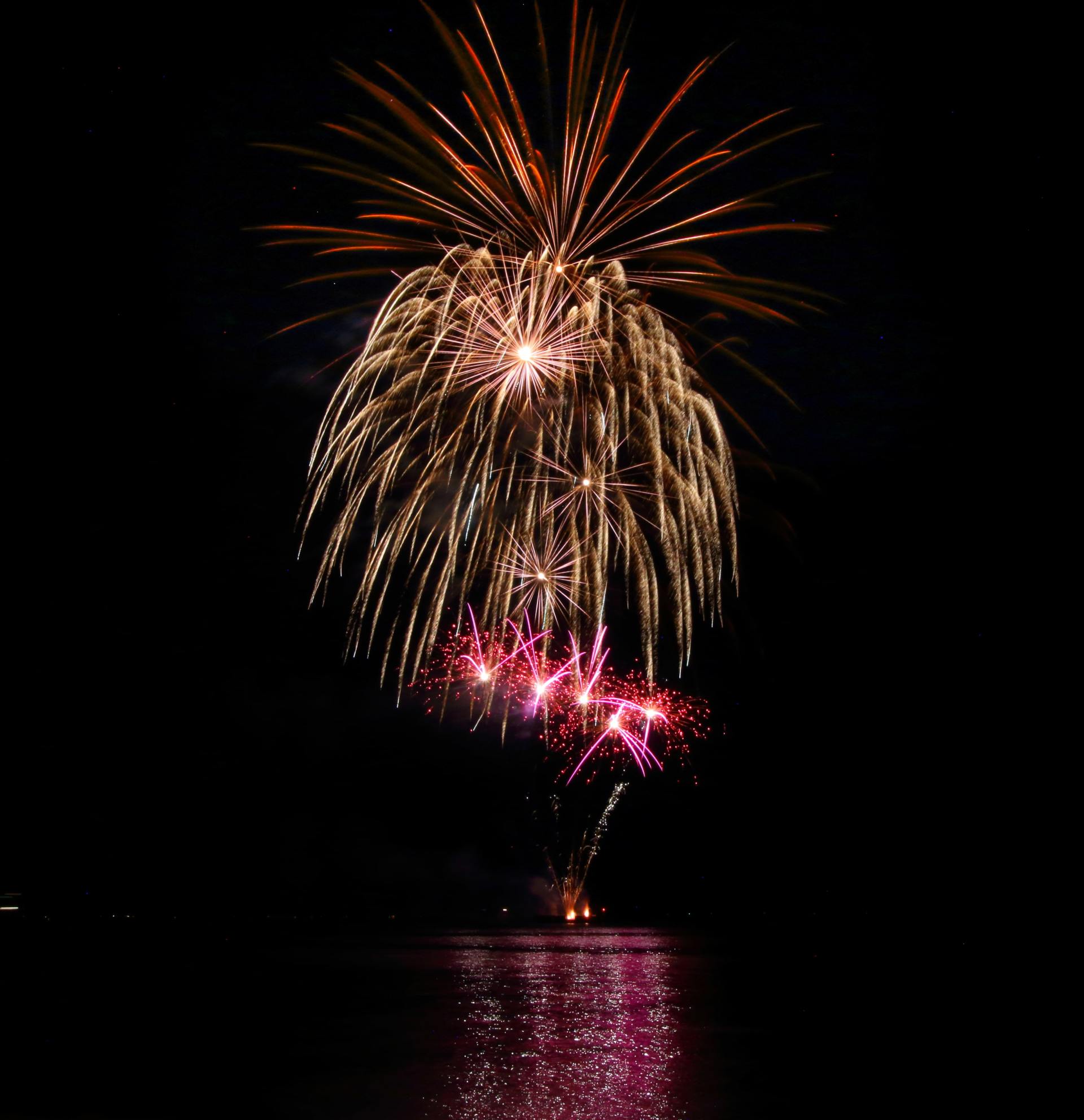 A fireworks display over a body of water
