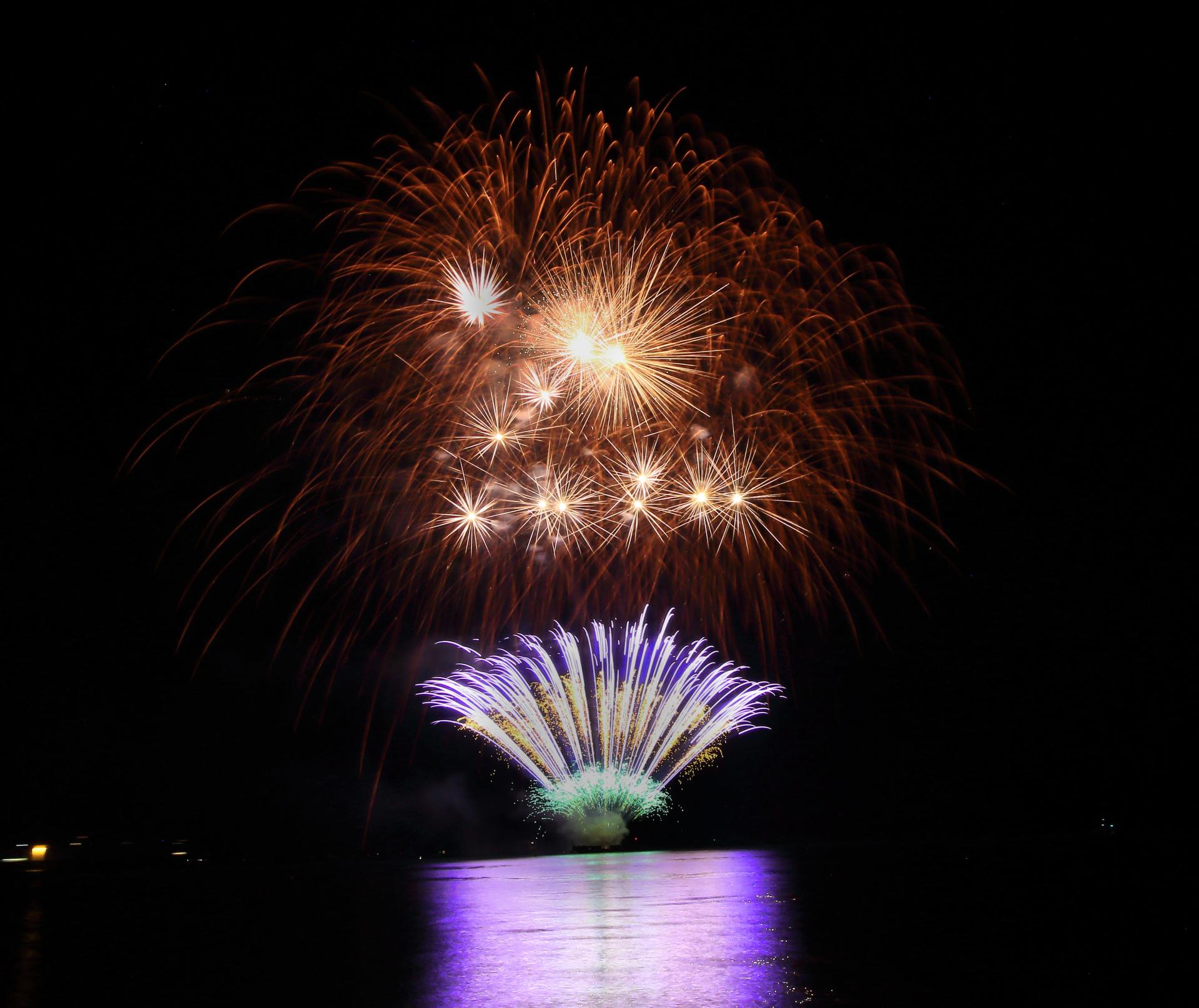 A fireworks display over a body of water at night