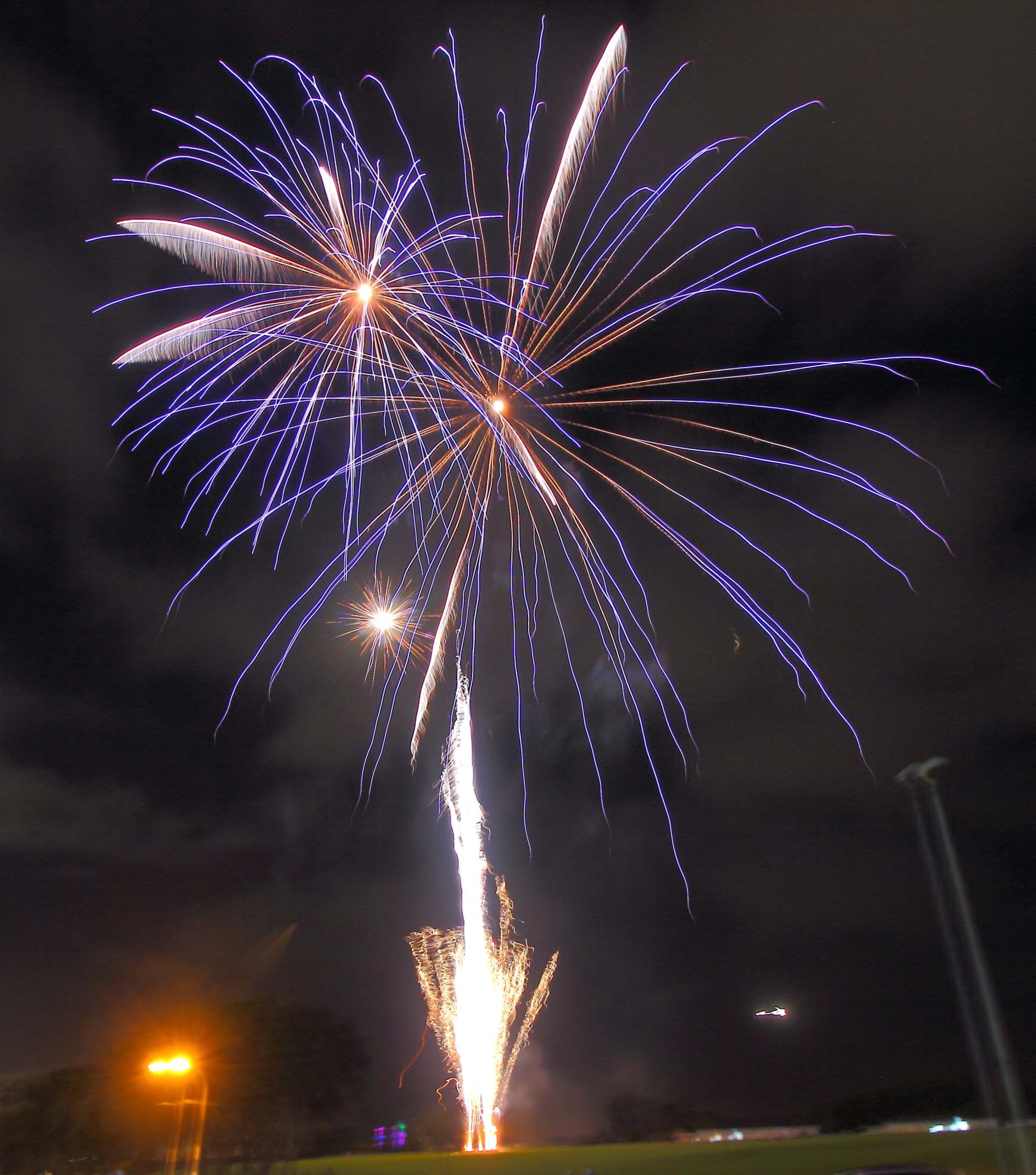 A fireworks display is going off in the night sky