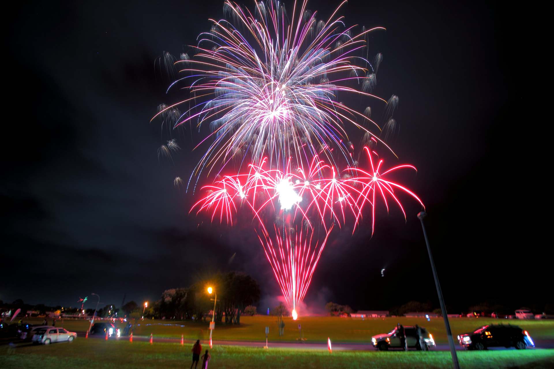 A large fireworks display is going off in the night sky Over Manukau reserve 