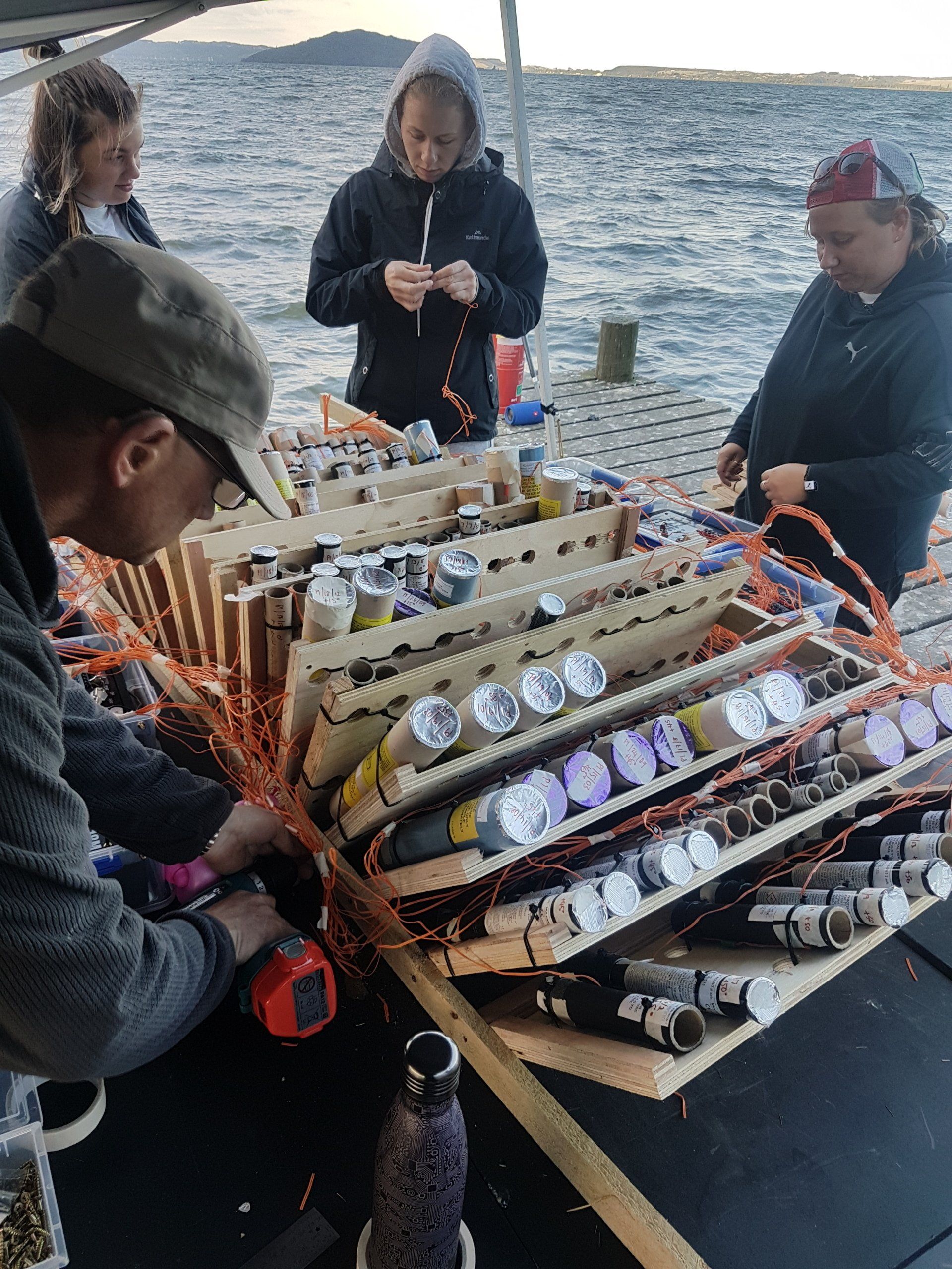 A group of people are working on fireworks on a boat.