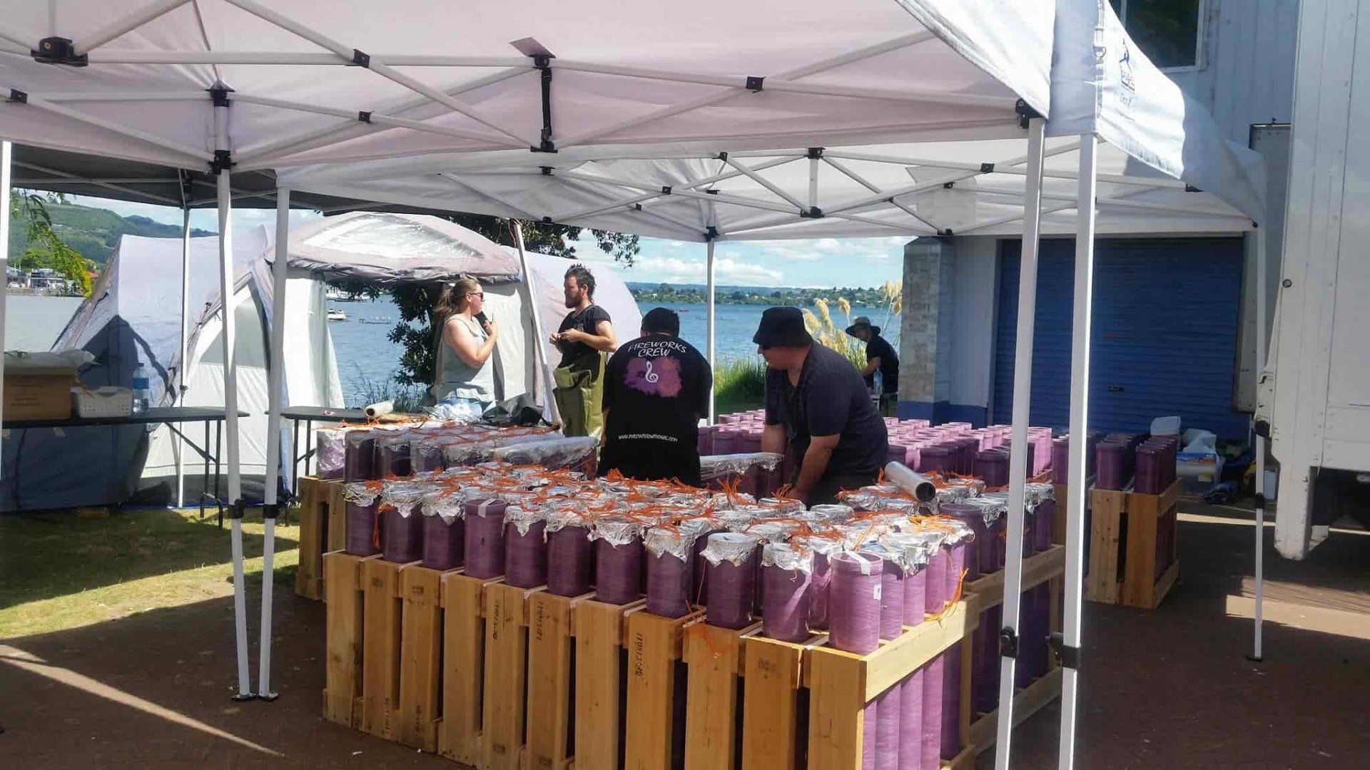 A group of people are working on a table under a tent.