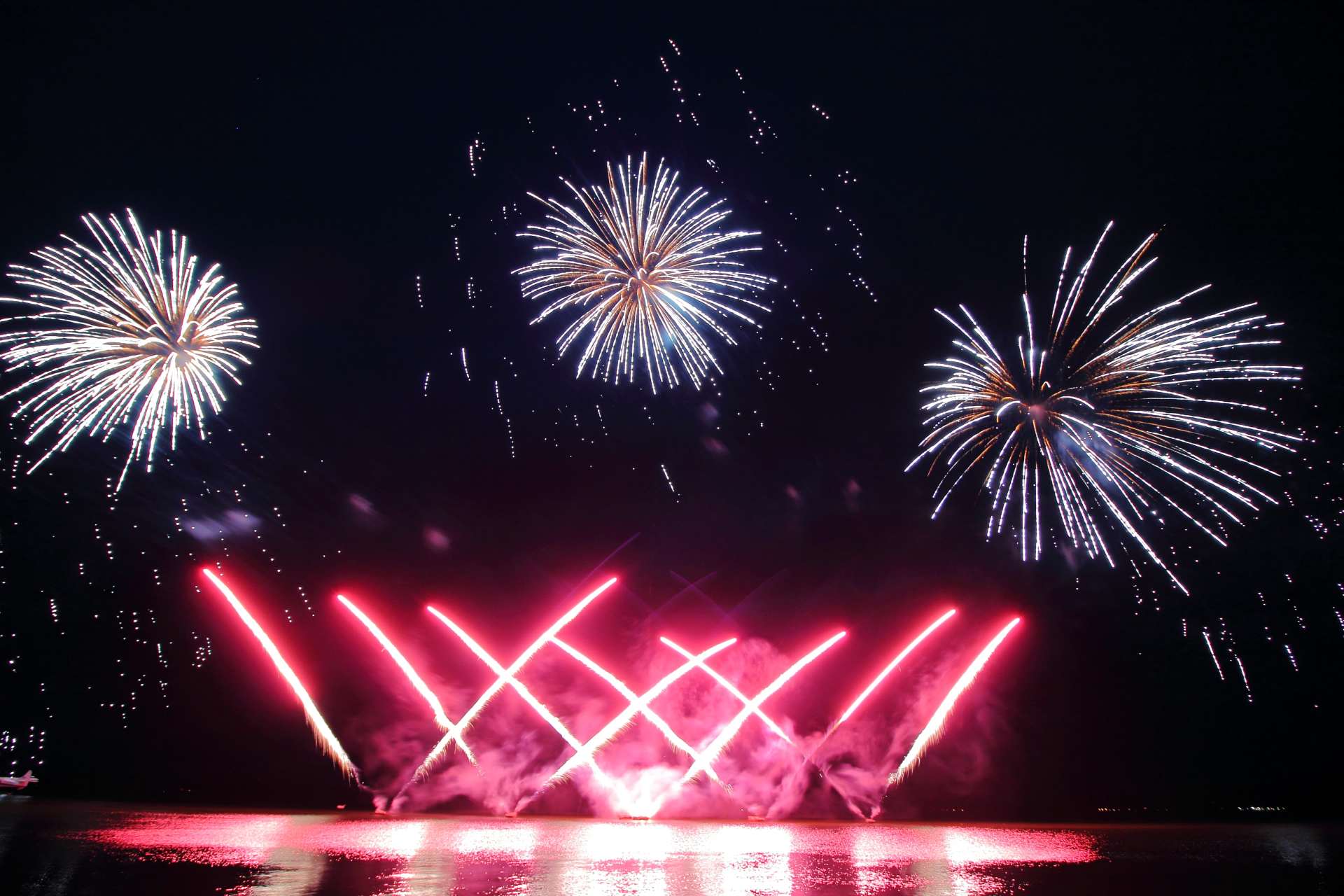 A bunch of fireworks are going off in the night sky