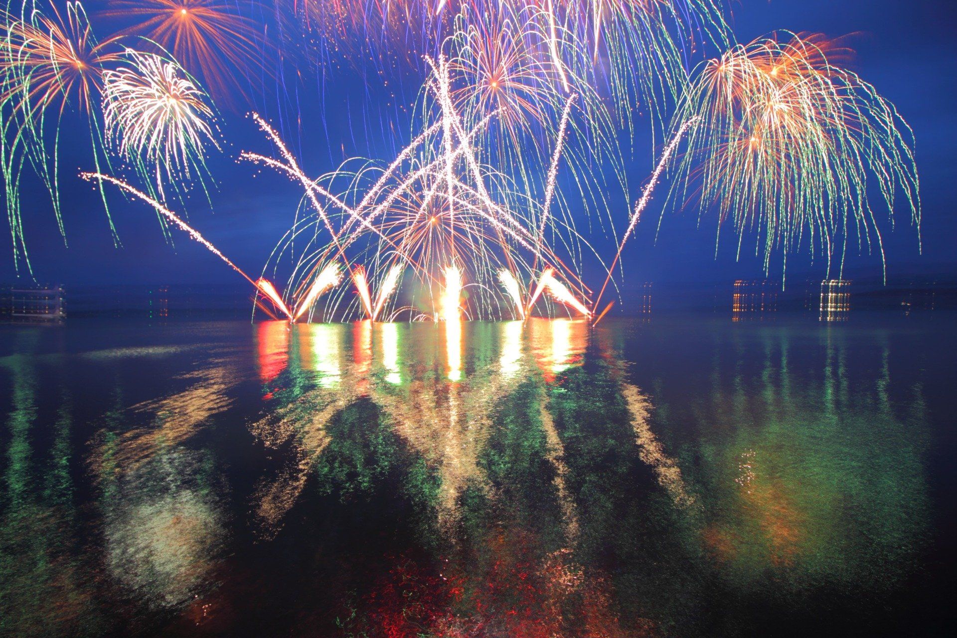 Fireworks are displayed over a body of water