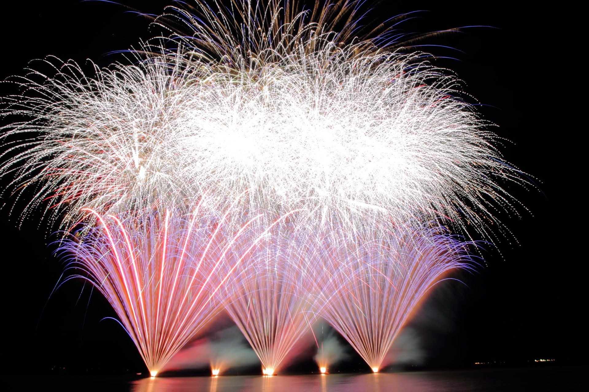 A bunch of fireworks are going off in the night sky