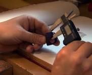 A person is measuring something with a digital caliper.