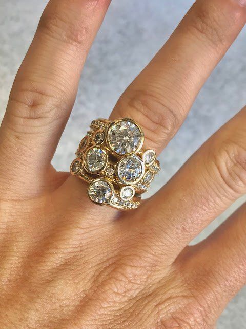 A woman 's hand with a stack of rings on it