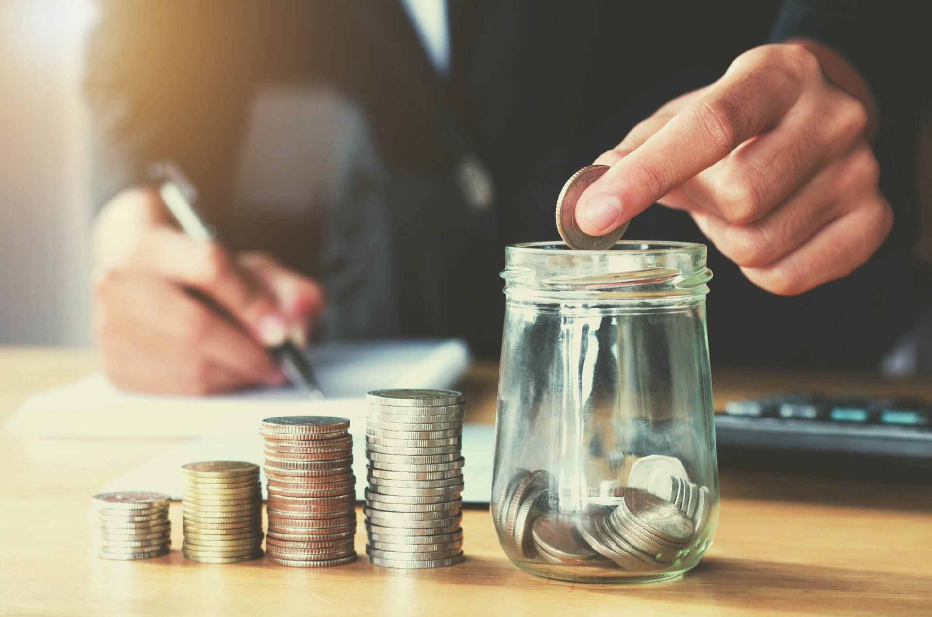 Man Putting Coin in Jar  — New Albany, IN — Russ Thomas Insurance Inc.