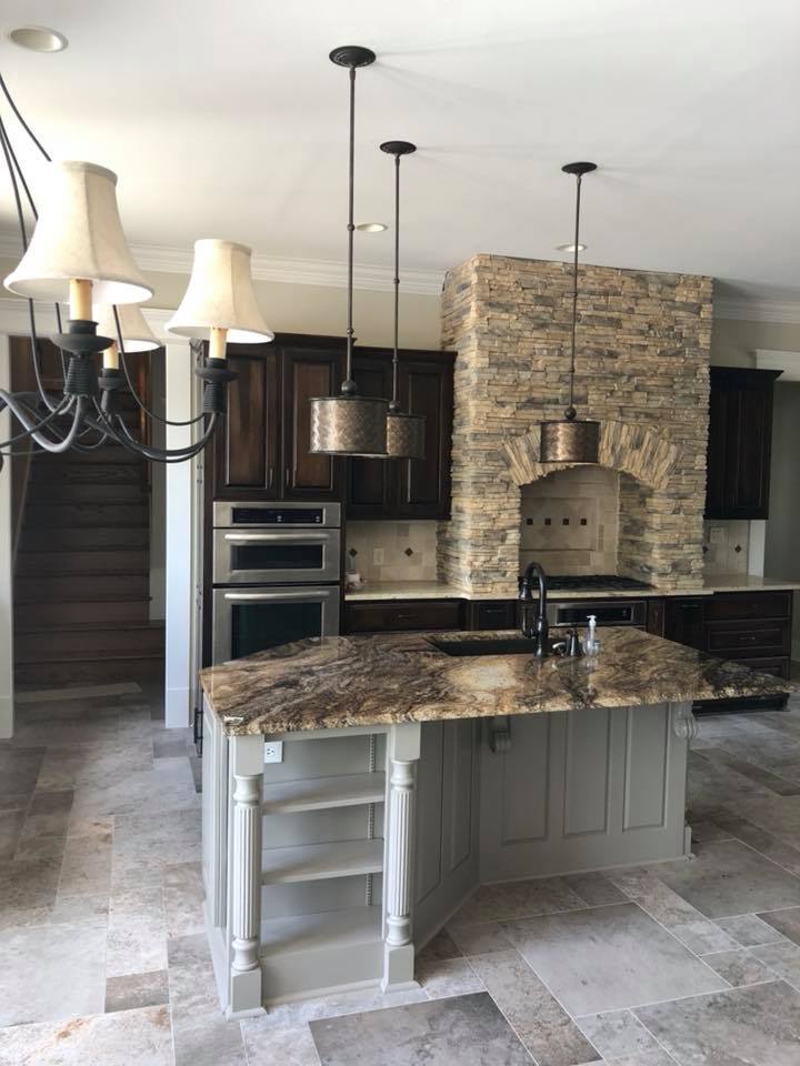 A kitchen with a large island and a stone fireplace