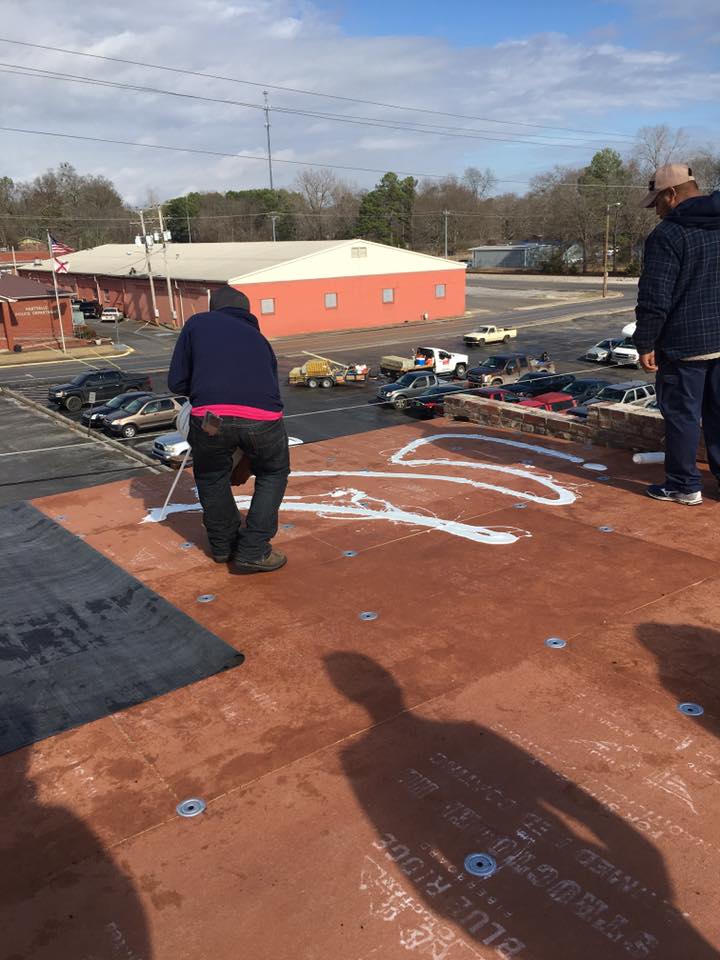 A group of people are standing on top of a roof.