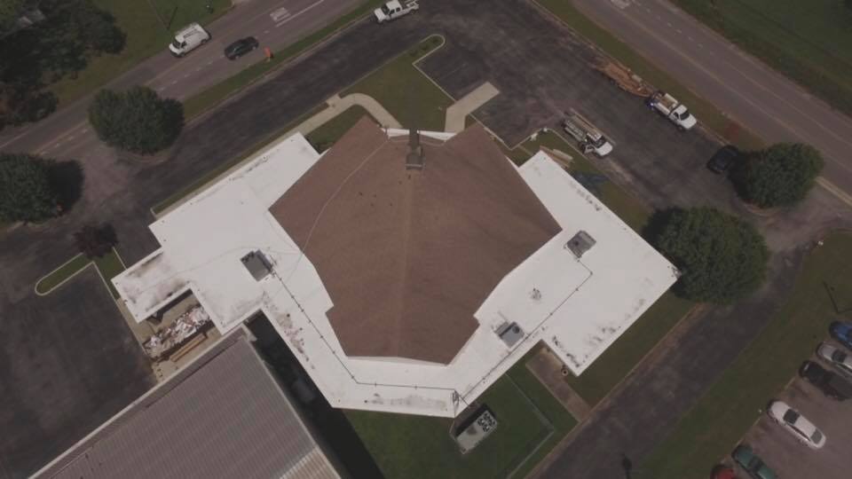 An aerial view of a building with a white roof