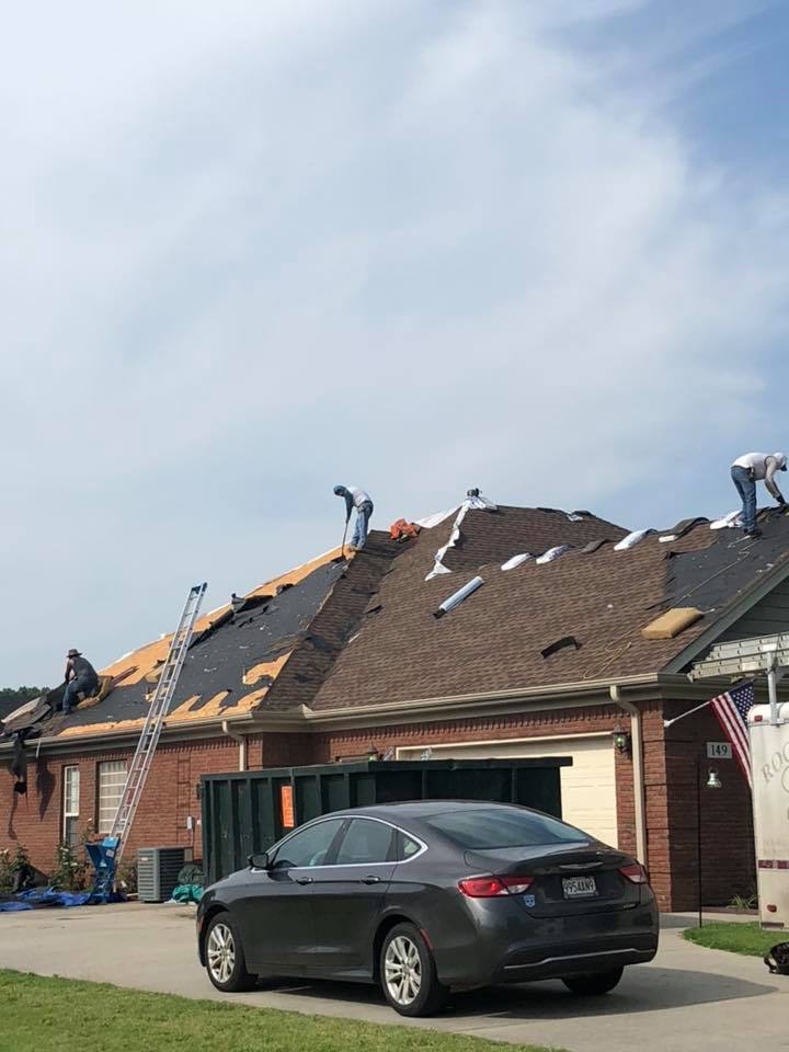 A car is parked in front of a house that is being remodeled.