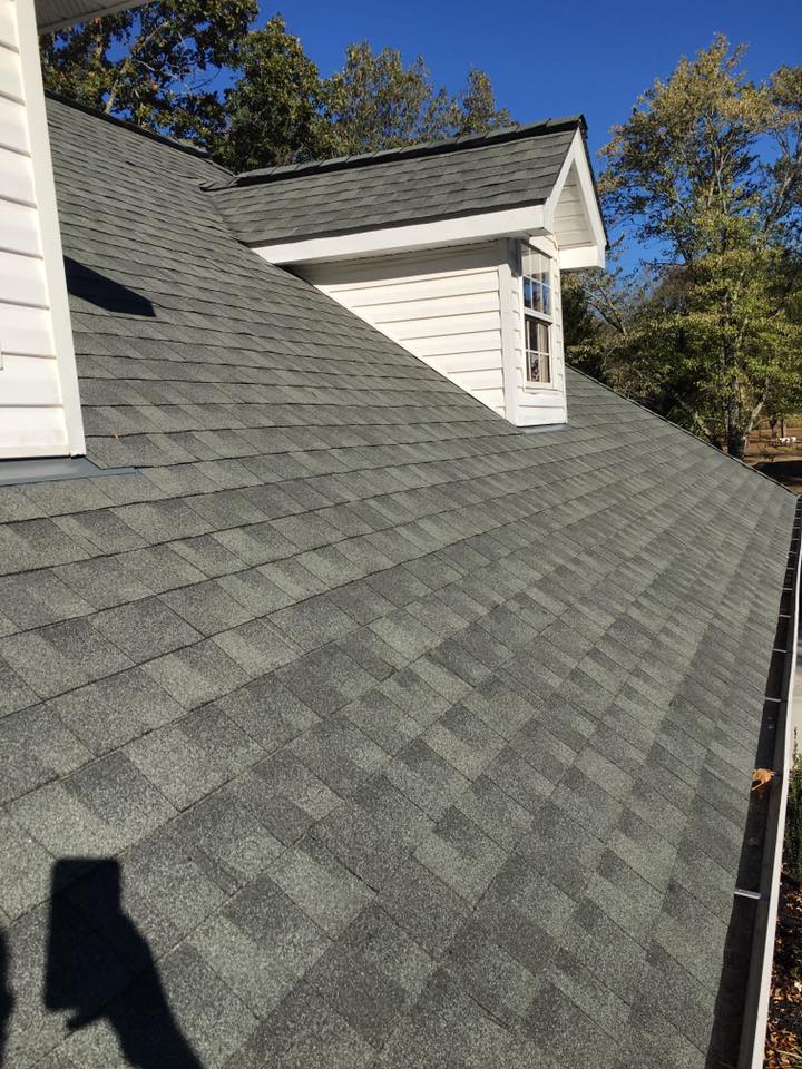 A close up of a roof of a house with a window.