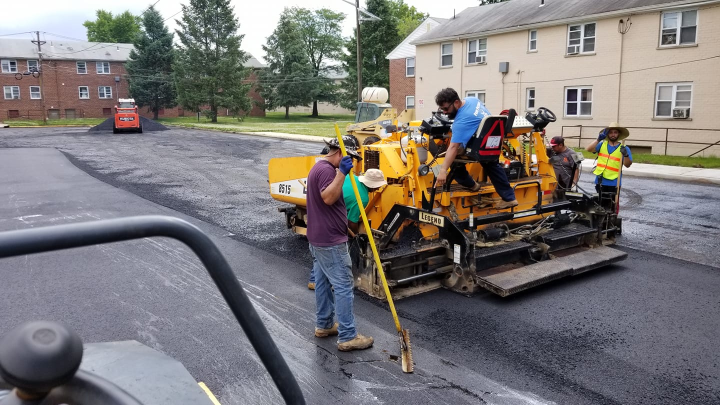 A group of construction workers are working on a road.