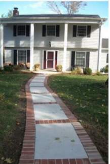 A white house with a brick walkway leading to it