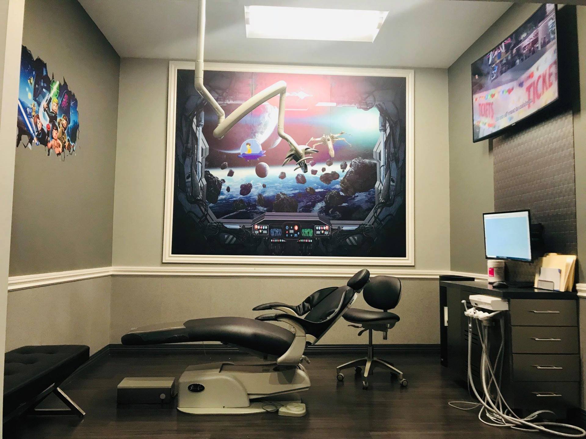 A dental office with a picture on the wall above the chair