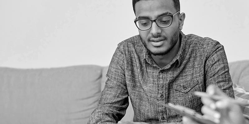 man with glasses sitting on couch