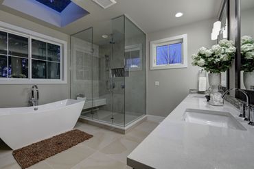 A bathroom with a bathtub , sink , and walk in shower.