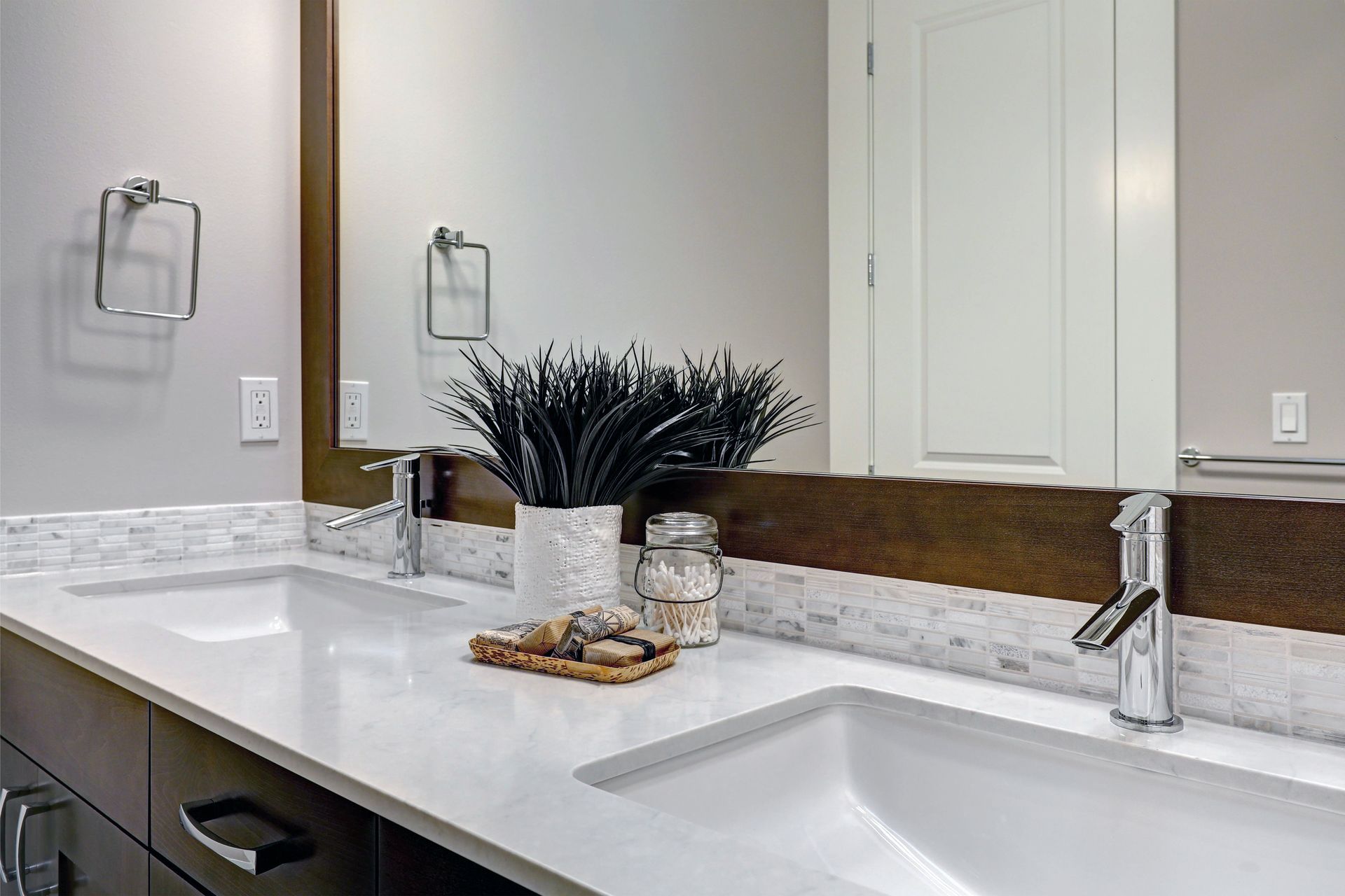 A bathroom with two sinks and a mirror.