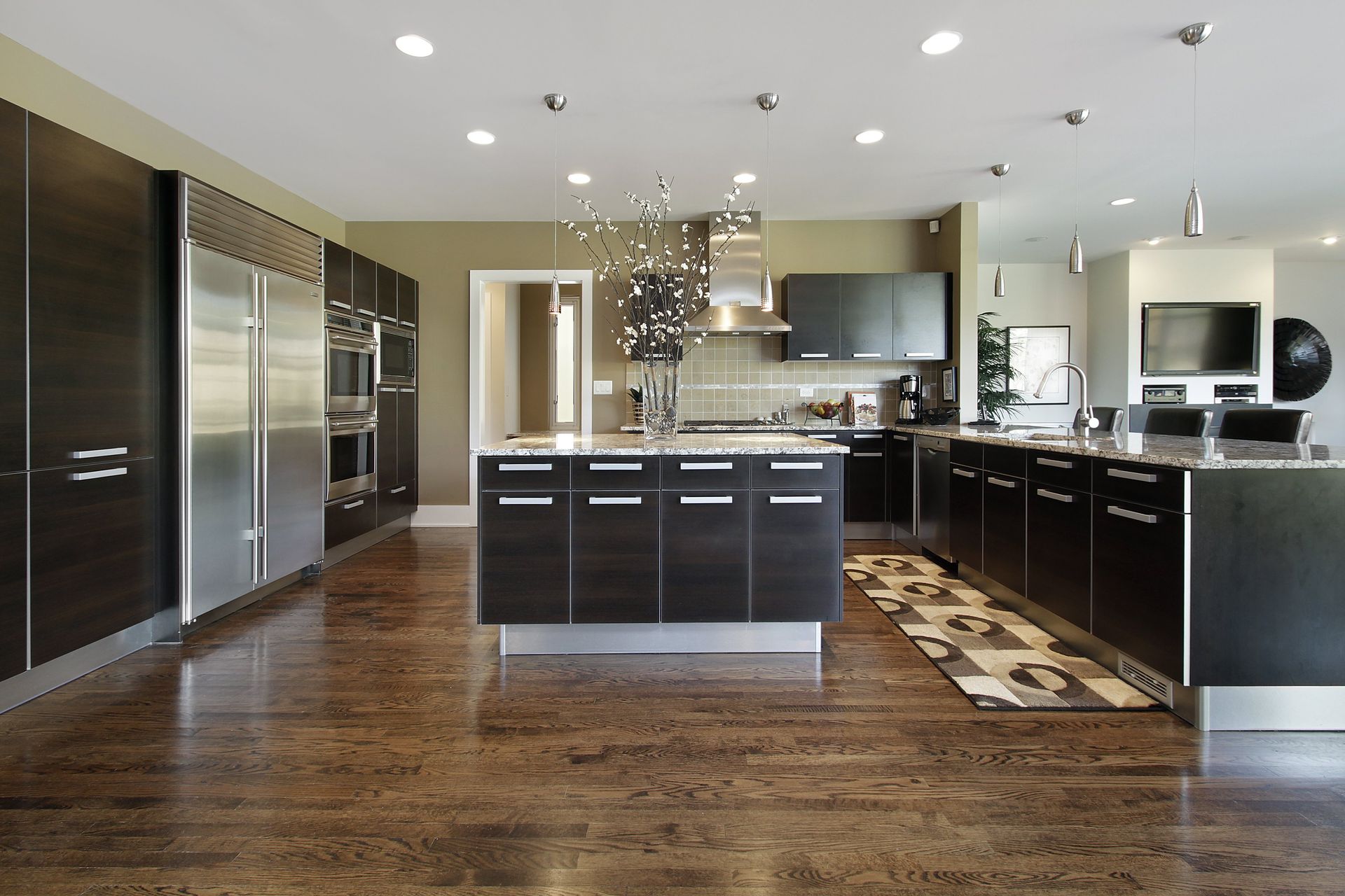 A kitchen with black cabinets and stainless steel appliances