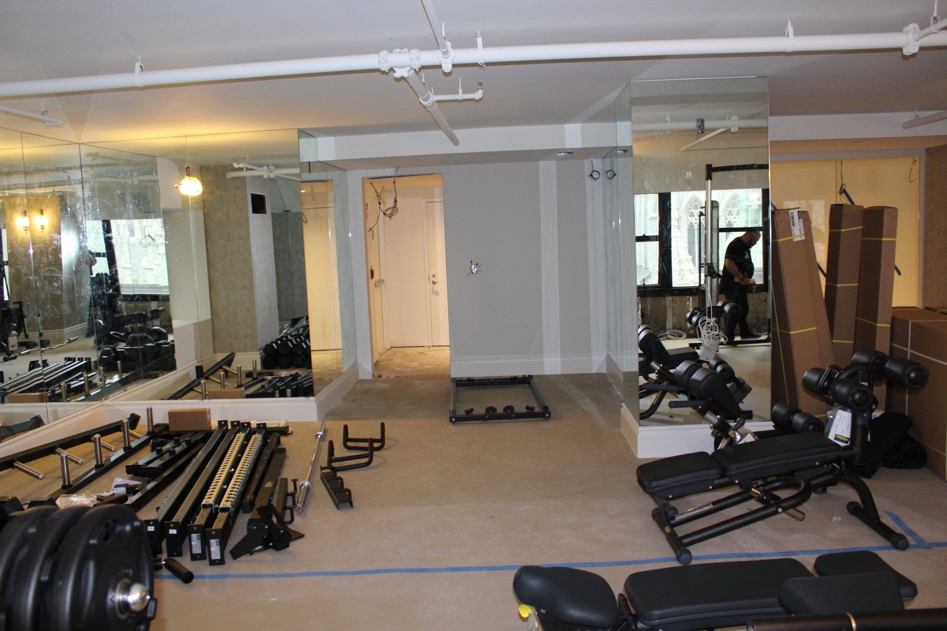 Spacious hotel gym with free weights and mirrored walls at Lotte New York Palace.