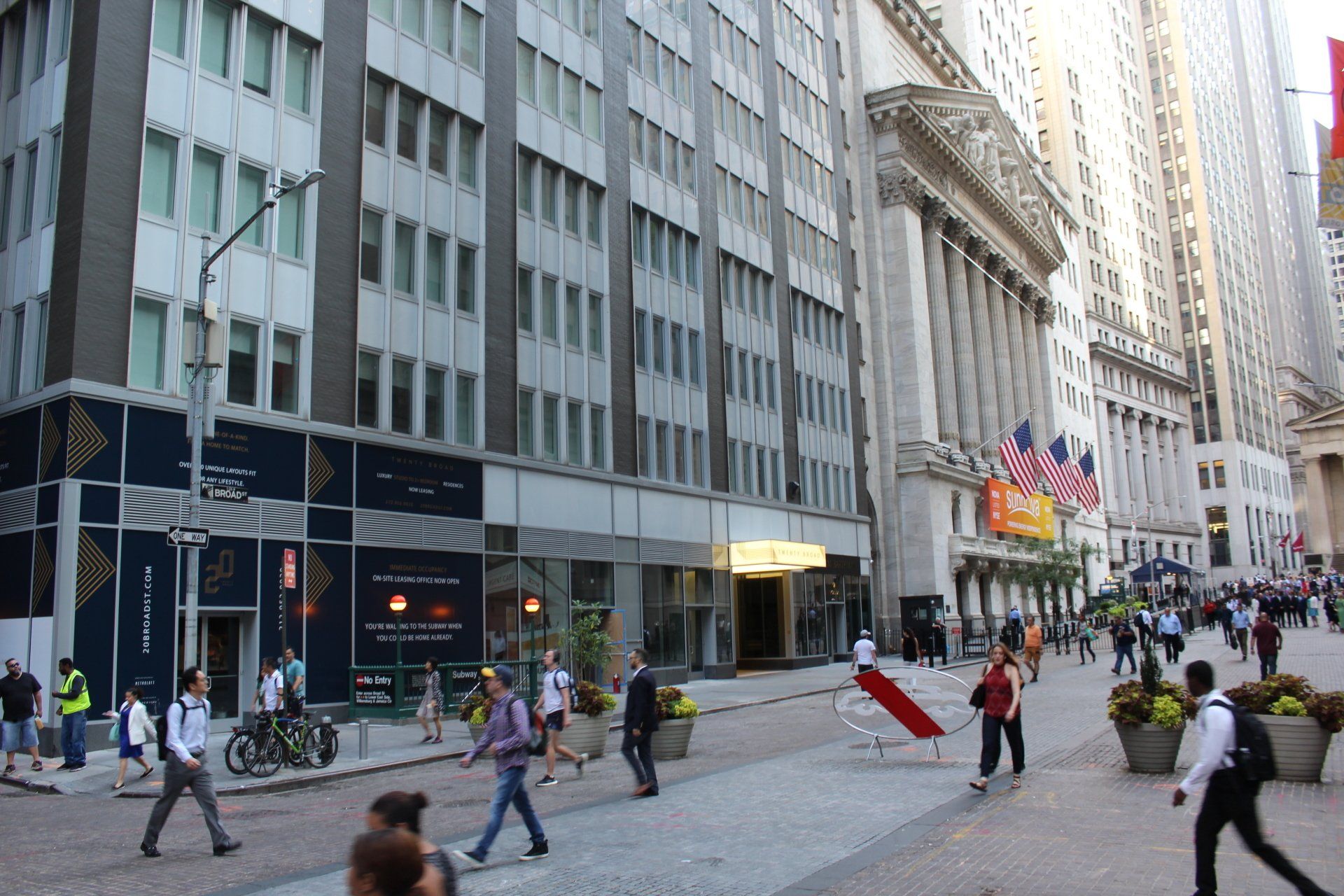 Side street view of Twenty Exchange Place with people walking and city skyscrapers.