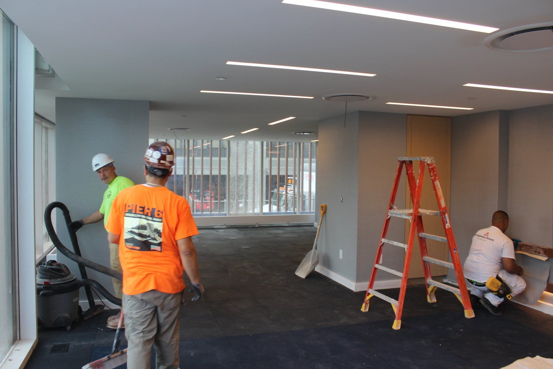 Construction crew working inside Quay Tower laying flooring and completing interior upgrades.