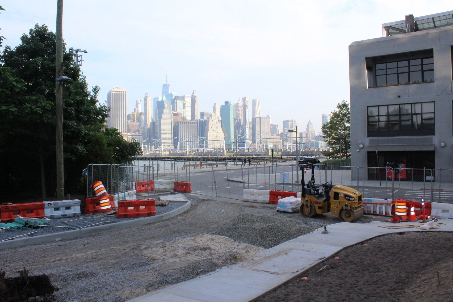 View of city skyline and construction site outside Quay Tower with roadwork and barriers.
