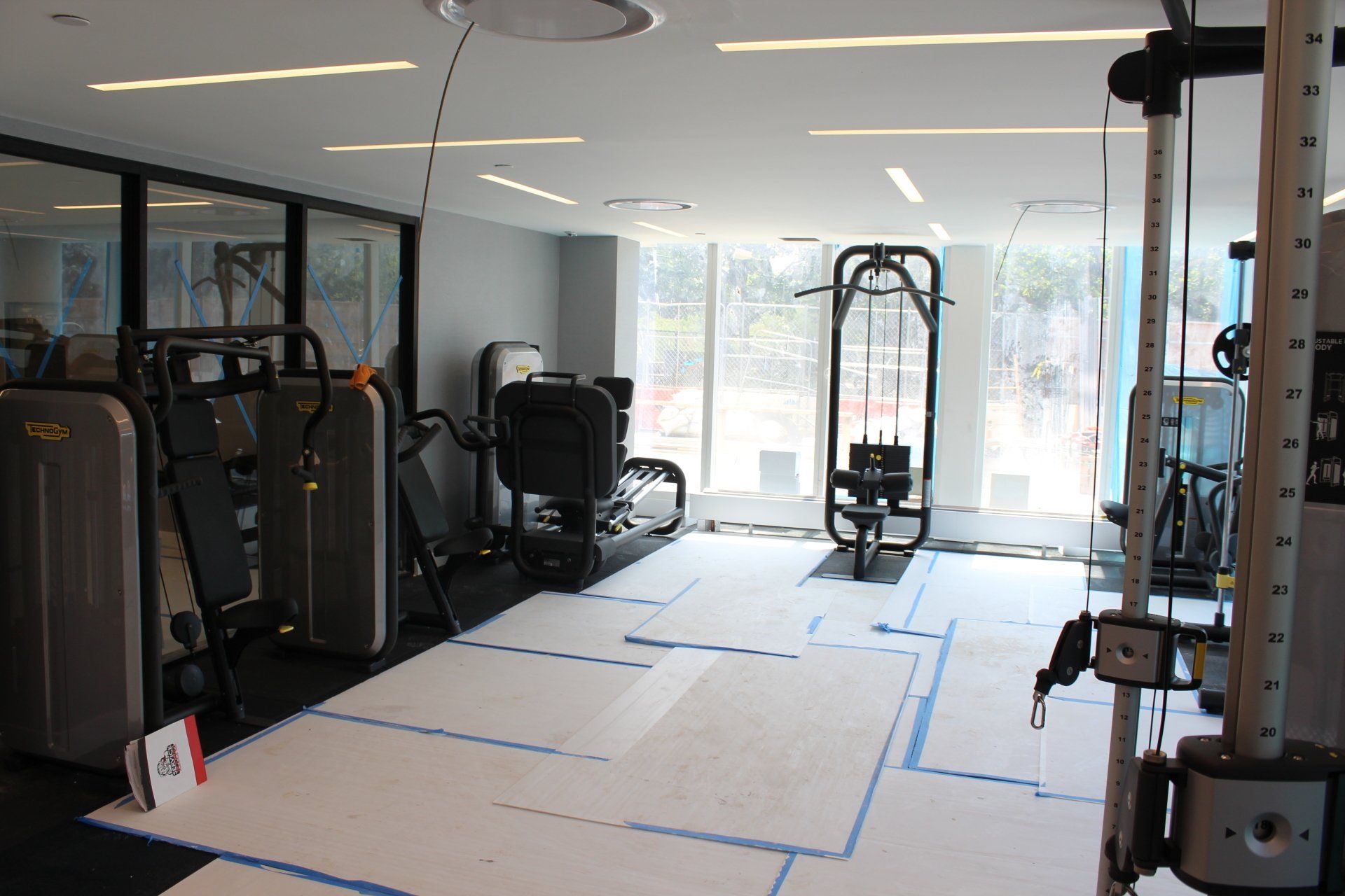 Quay Tower modern gym space with workout machines and large windows under installation.