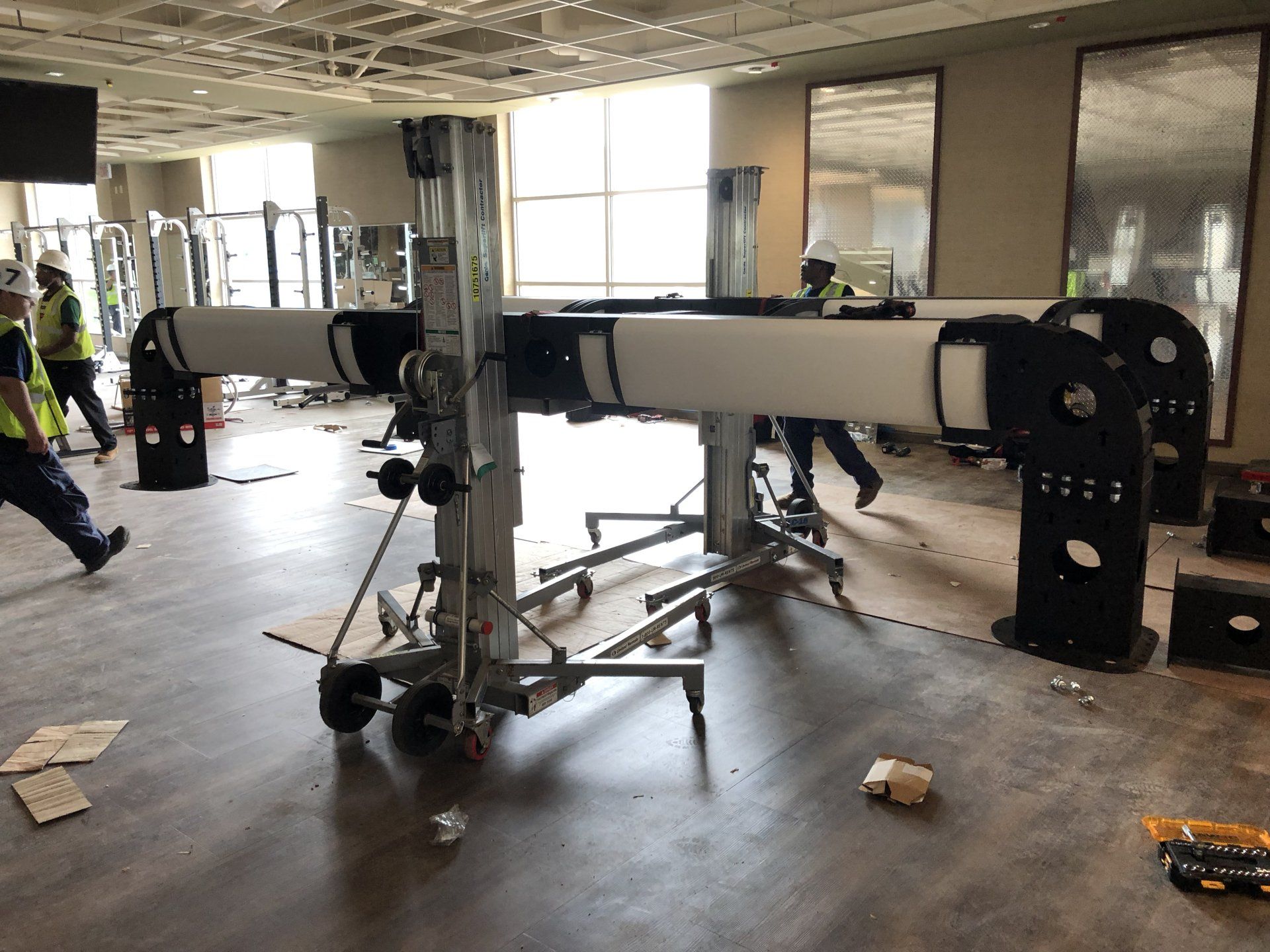 Lifetime Athletics gym equipment installation with weight machine assembly in progress.