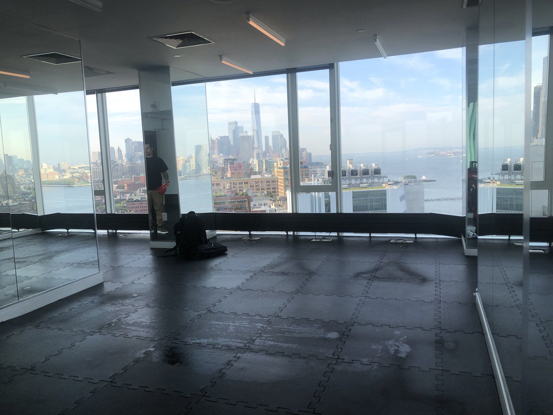 Empty gym floor at The Standard with large glass windows showcasing the Manhattan skyline.