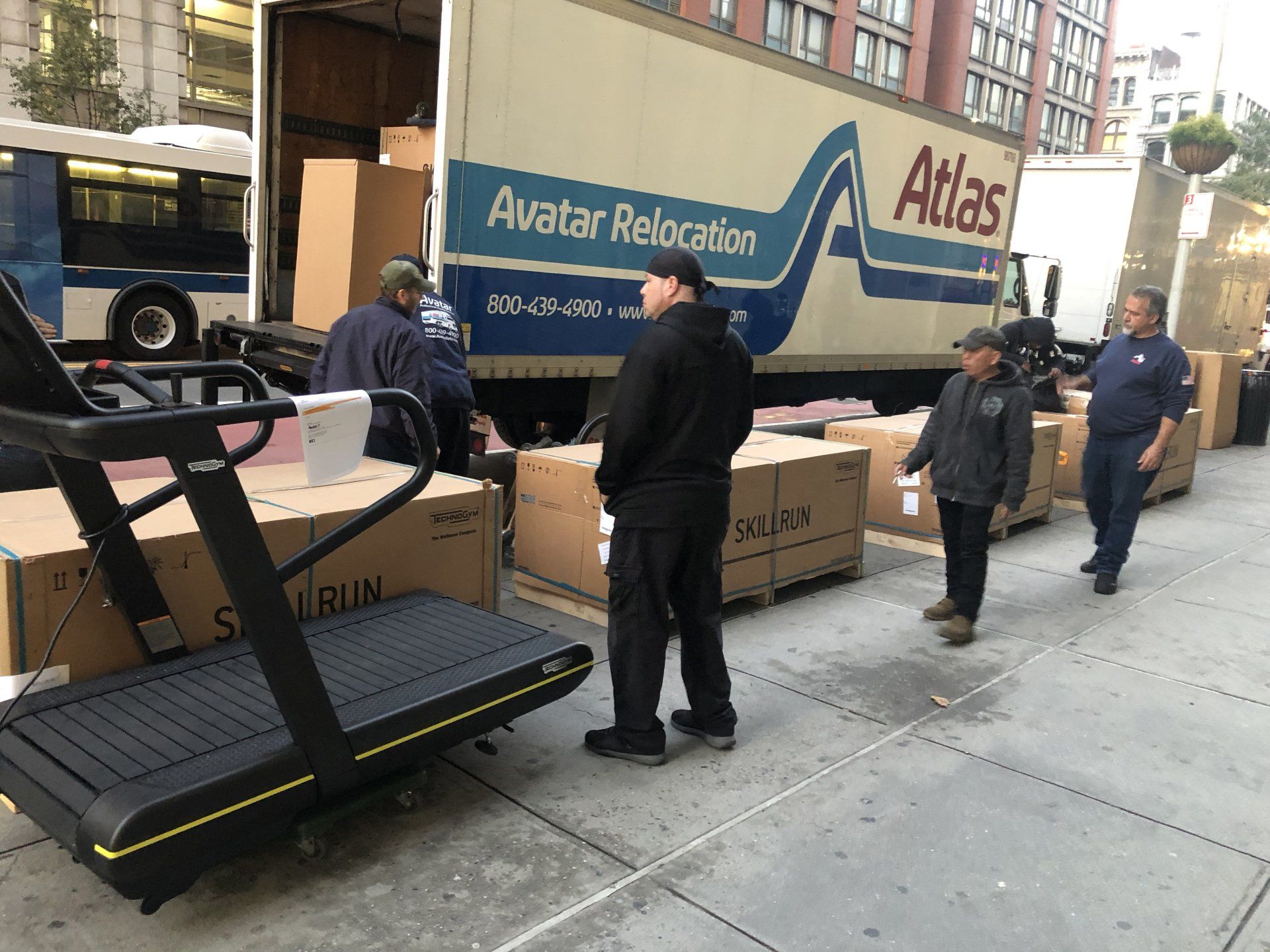 Workers unloading treadmills from truck for Rumble Fitness gym setup