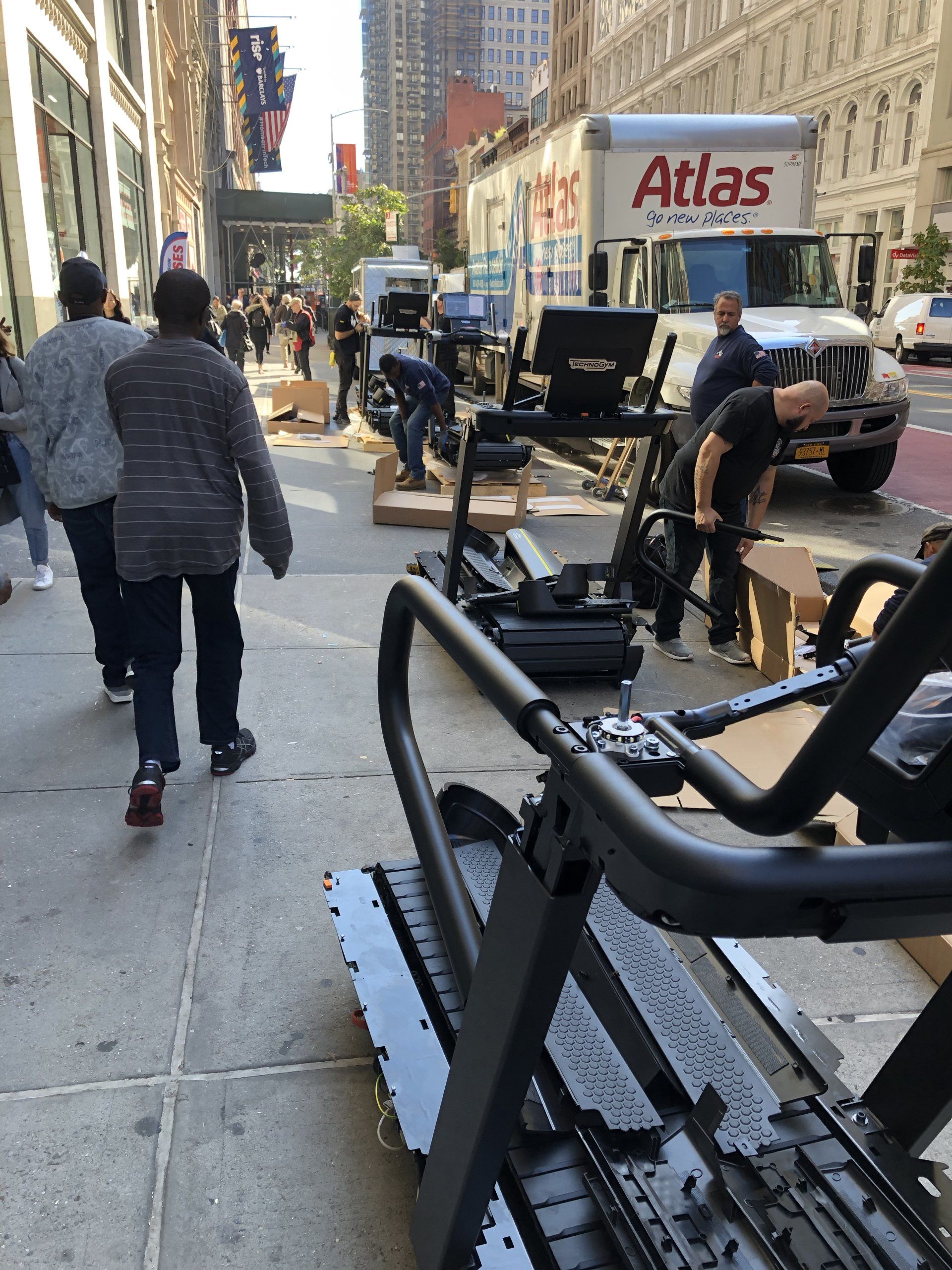 Crew moving treadmill and boxes during Rumble Fitness equipment delivery