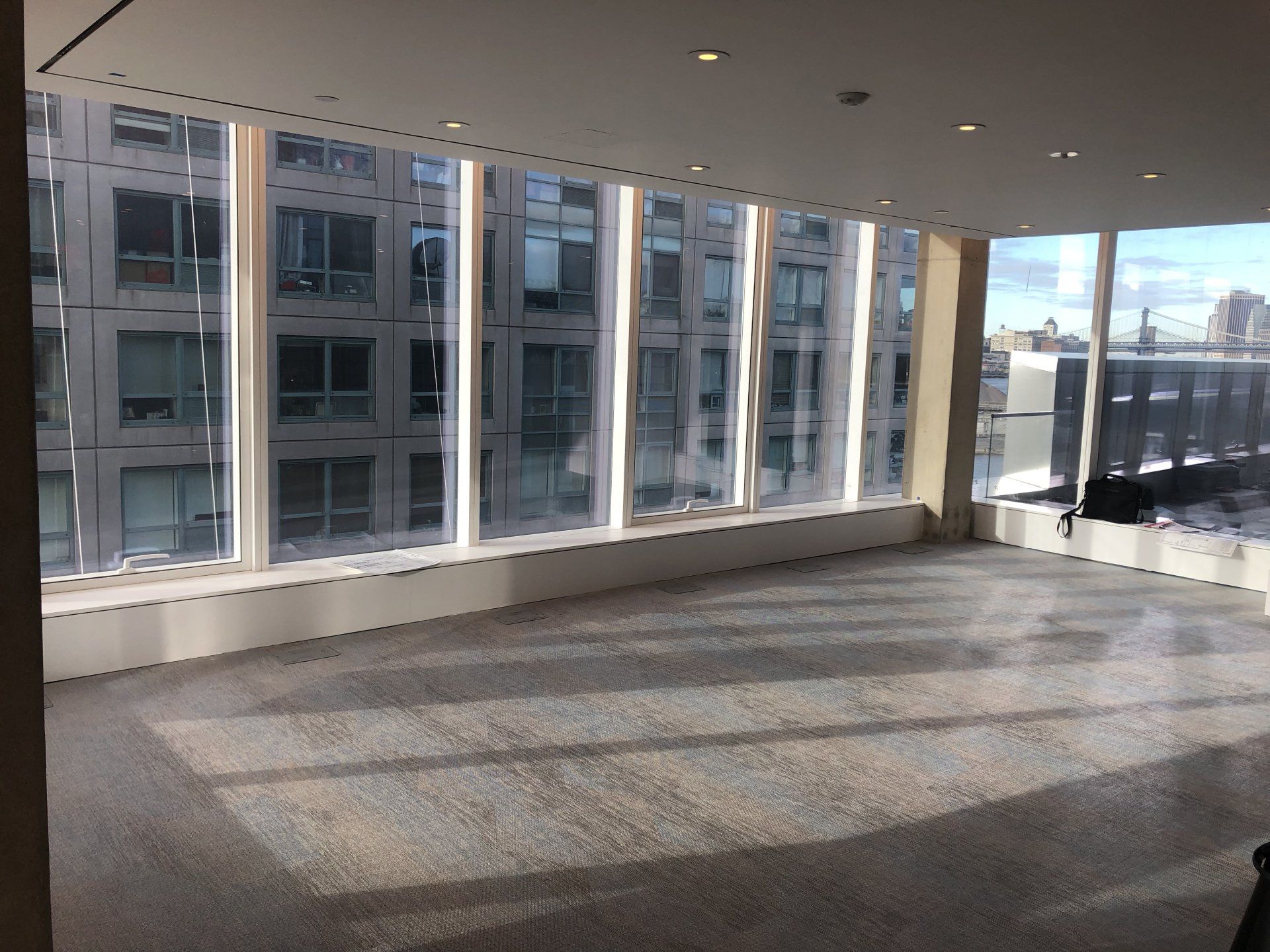 Empty workout studio with large windows overlooking city view in apartment complex