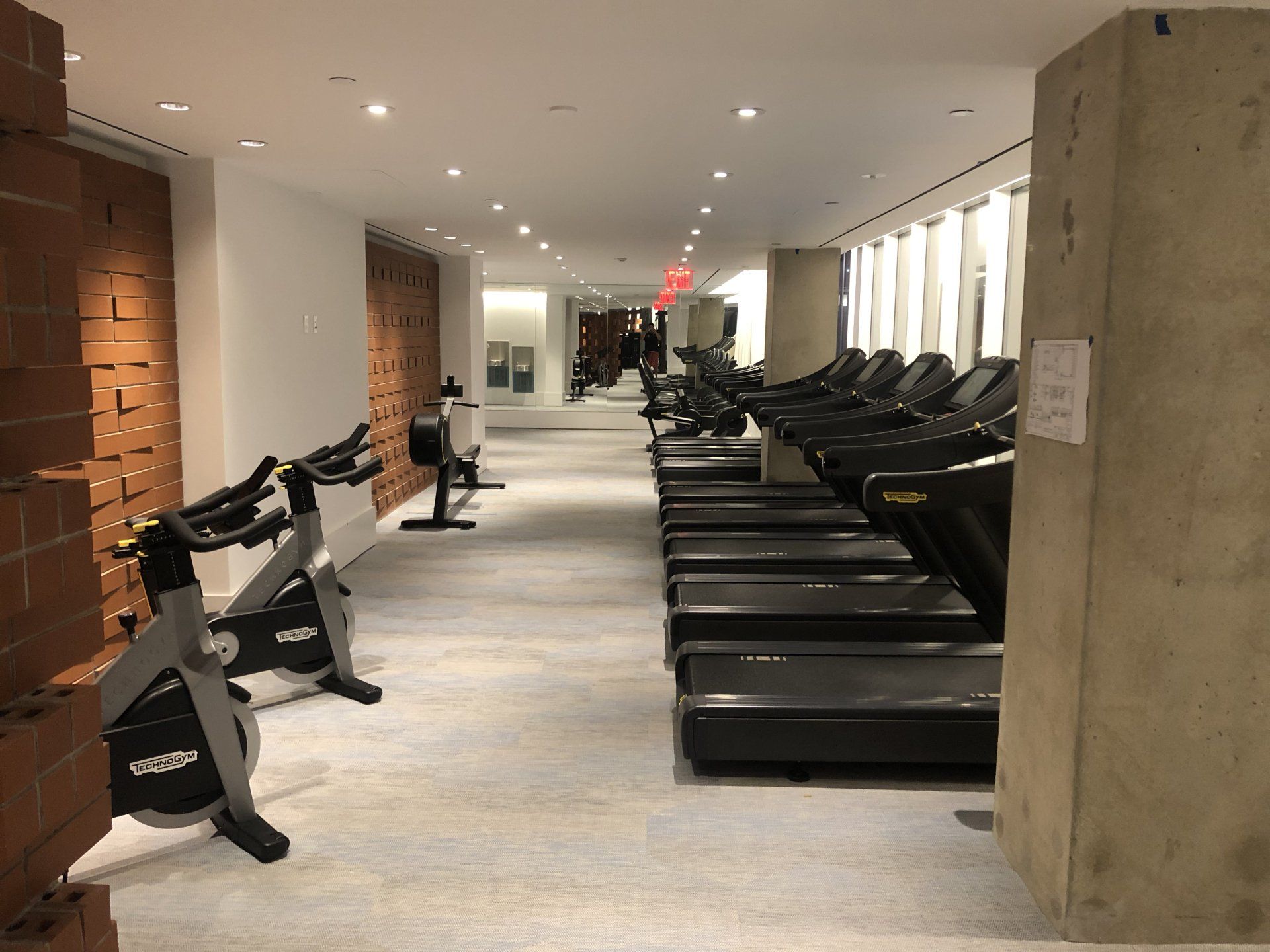 Spacious fitness center lined with treadmills and stationary bikes at Williamsburg Waterfront Apartments