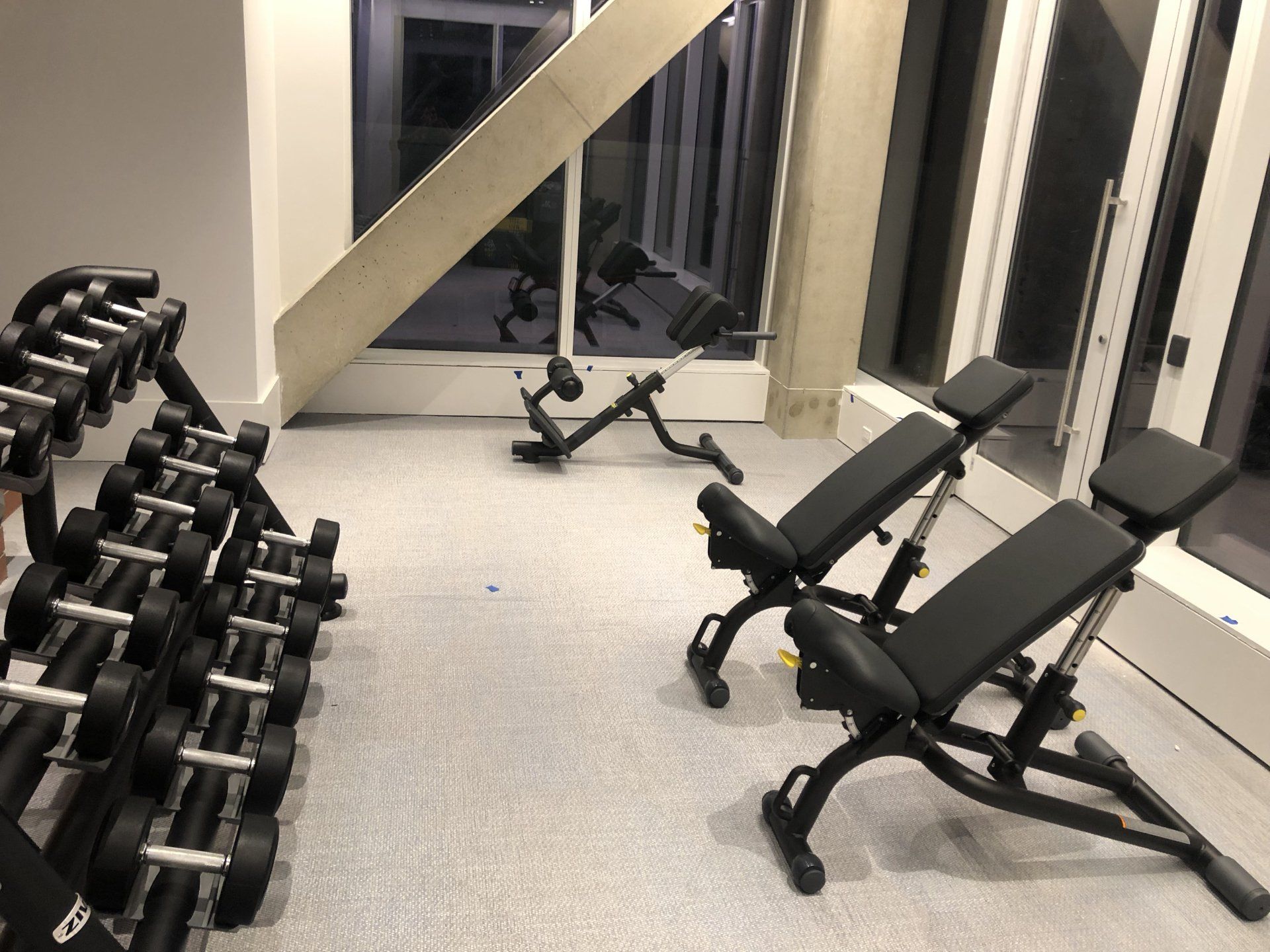 Dumbbells and adjustable benches in waterfront apartment gym.
