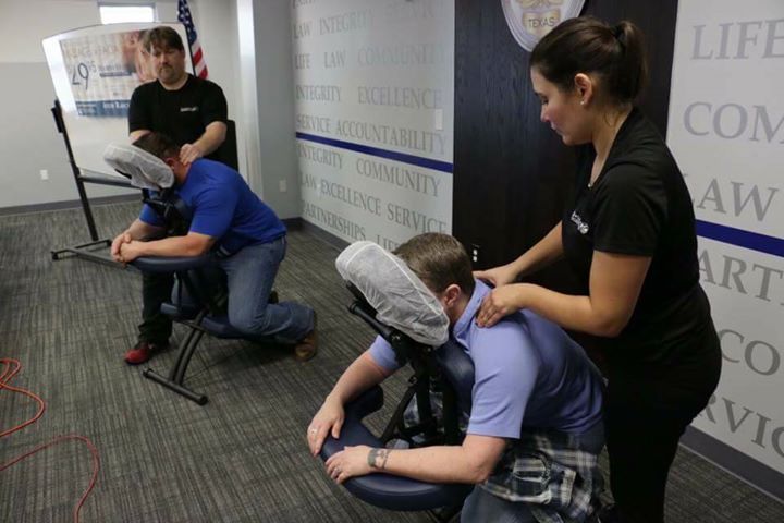 A woman is giving a man a massage in a chair