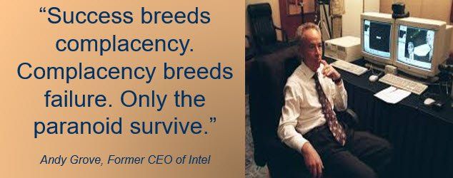 A man sitting in front of a computer with a quote from andy grove