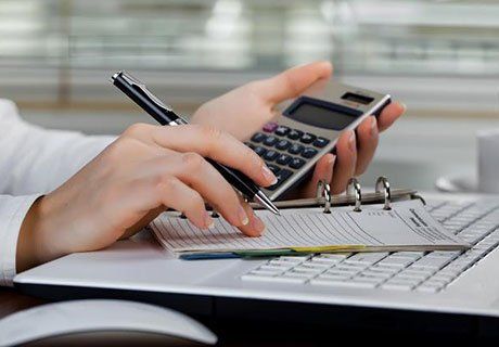 Person Holding a Pen and Calculator — Olympia, WA — Bliss & Skeen, CPAs