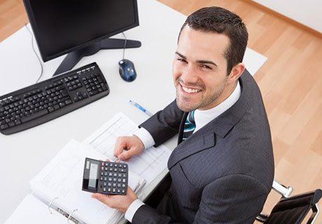 Accountant Holding a Calculator — Olympia, WA — Bliss & Skeen, CPAs