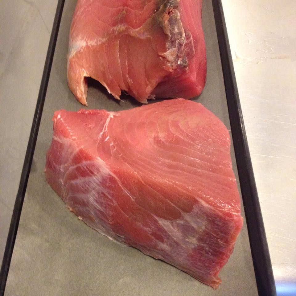 Two pieces of raw meat are on a tray